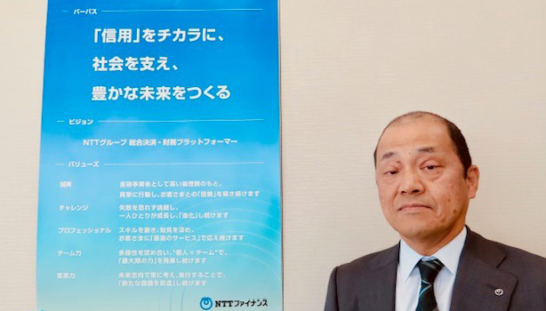 パーパスの記載された張り紙の前に立つ伊藤 正三代表取締役社長