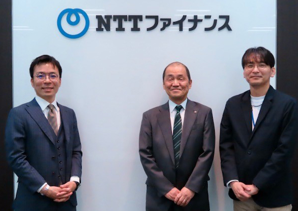 NTTファイナンスのロゴの前で撮影された集合写真